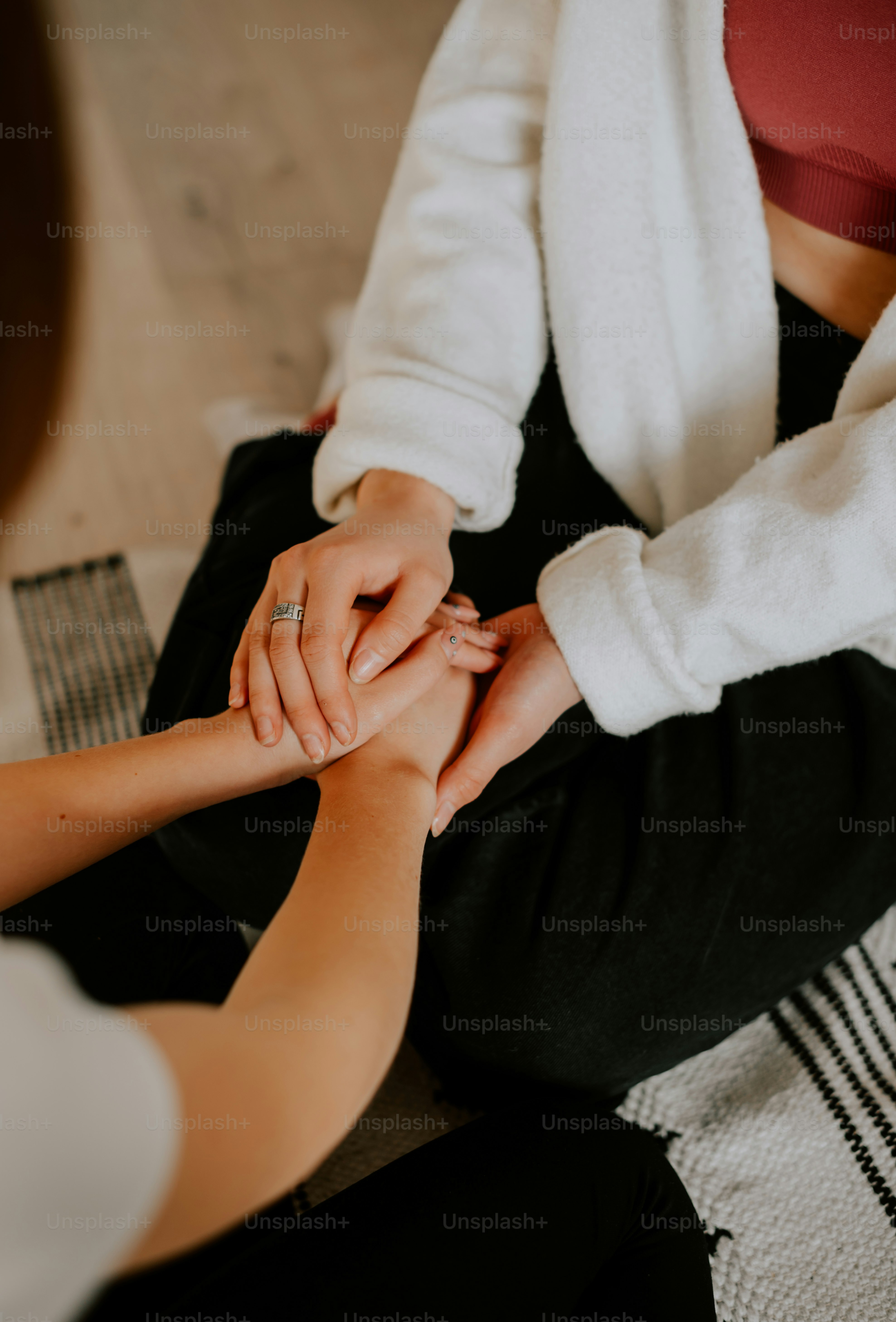 two people sitting on the floor holding hands